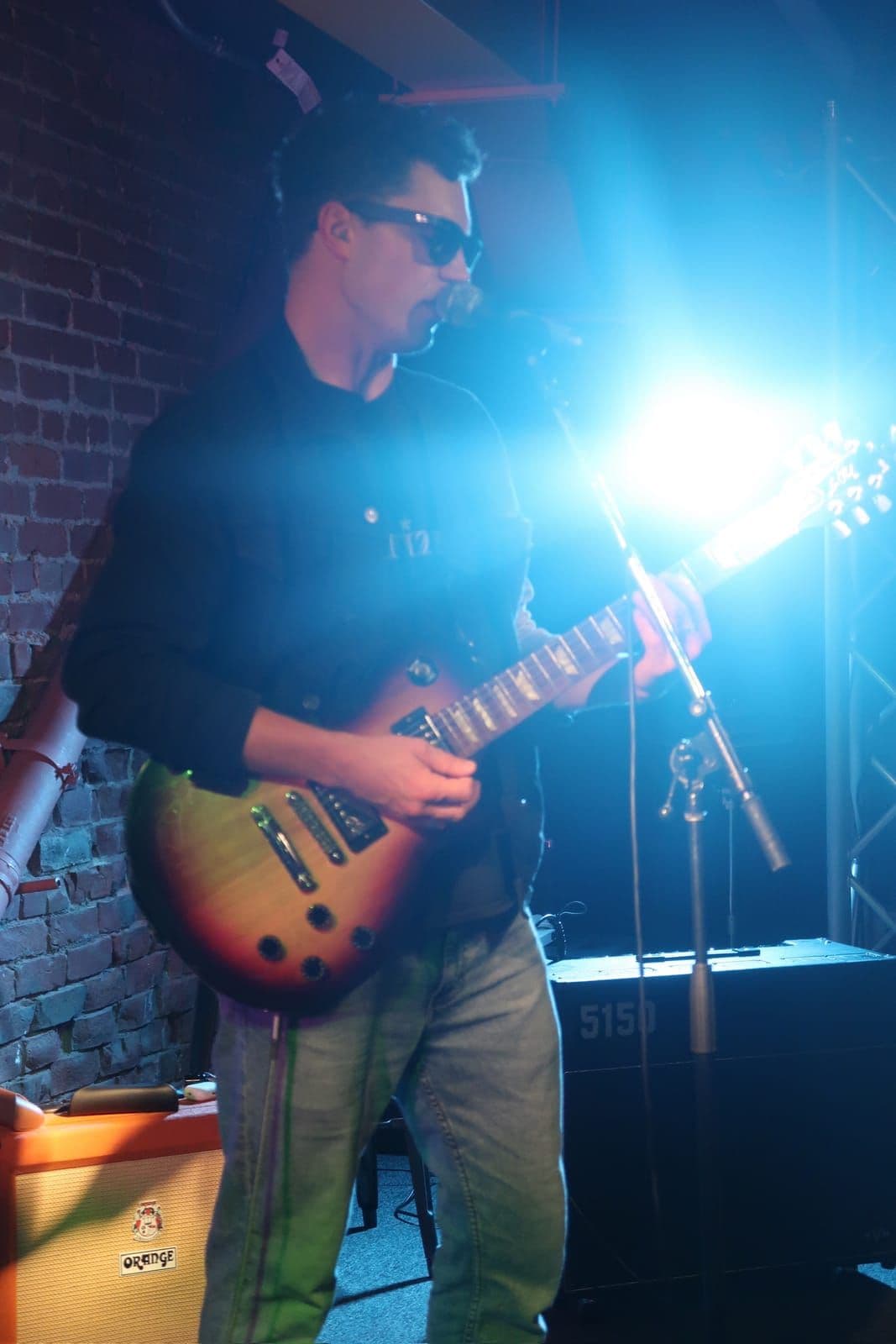 The Vagrancy frontman singing and playing guitar under stage lights